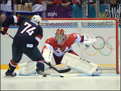 Hockey goalie blocking a shot on goal