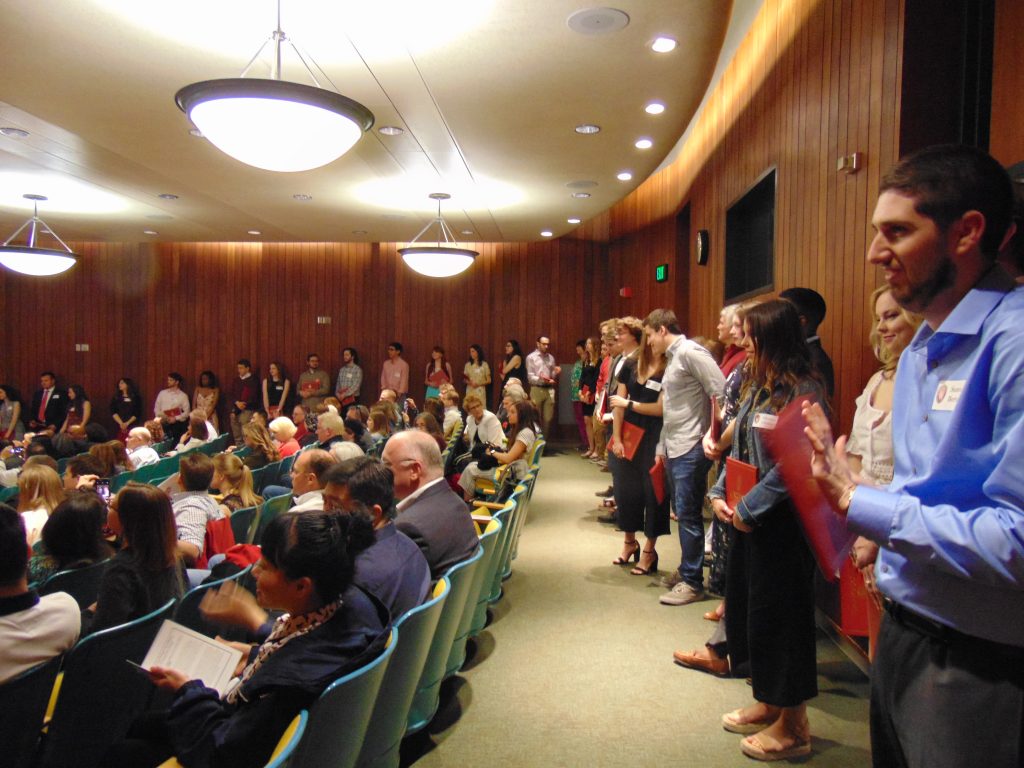 Graduates line up alphabetically and wait for their names to be called