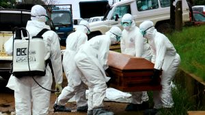 Burial team workers handling a casket with the human remains of an Ebola victim in Monrovia. Photo credit: Alexander Wiaplah