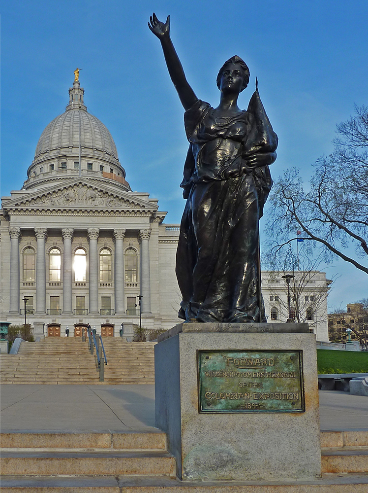 The photo is of a copy of the figurehead statue "Forward", which was created at the Columbian World Exposition in Chicago (1893) by artist-in-residence Jean Pond Miner. The title of the statue adopts the motto of the State of Wisconsin, and funding was provided by the women of Wisconsin. Following display in Chicago, the statue was initially installed at the State Capitol in Madison, Wisconsin. It has now been removed to the interior of the Wisconsin Historical Society, and a copy is on display near the State Capitol at the corner of State Street and Mifflin Street.