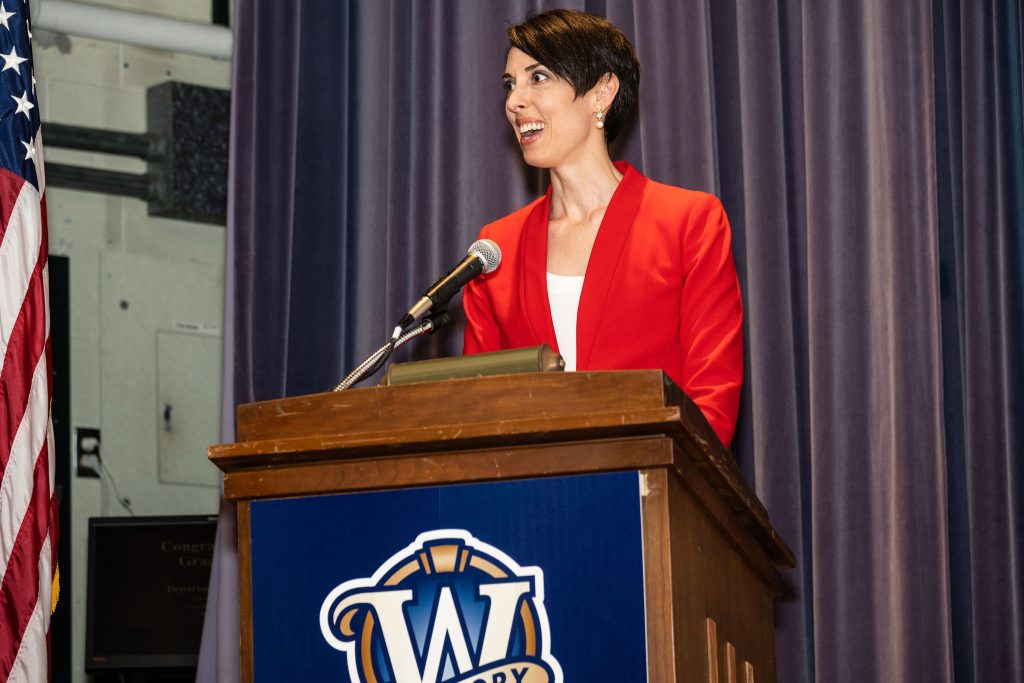 Professor Gloria Whiting recognizes graduates by name as they walk in front of the stage.