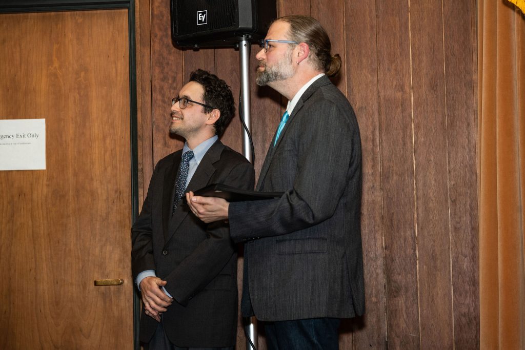 Professor Daniel Stolz and Undergraduate Advisor Scott Burkhardt prepare to hand certificates to graduates.